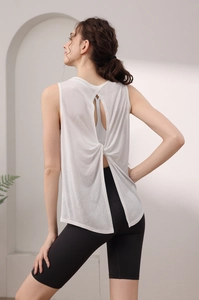 Macro view of white yoga tank top featuring cross-knot back and breathable mesh fabric