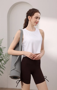 Détail du débardeur de sport blanc côtelé et du short de yoga marron avec laçage latéral