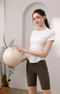 Dettaglio della t-shirt da yoga bianca e dei pantaloncini da ciclista a vita alta oliva