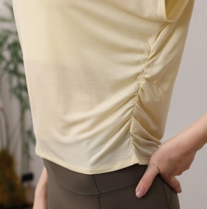 Κοντινό πλάνο κίτρινου yoga t-shirt με λεπτομέρειες σούρες και ελαφριά υφή υφάσματος