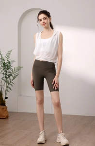 Détail du haut de yoga sans manches à capuche blanc et short de cyclisme taille haute olive