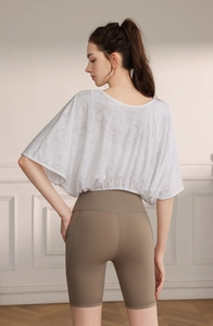 Detailed back view of a white jacquard batwing sleeve top with high-waist yoga shorts