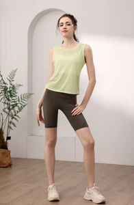 Close-up of breathable pale green sleeveless yoga vest and olive green biker shorts