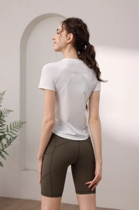 Dettaglio della maglietta da yoga bianca e dei pantaloncini da ciclista verdi
