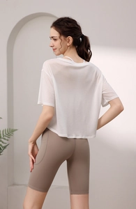 Nahaufnahme von weißem, atmungsaktivem Yoga-T-Shirt und brauner Radlerhose mit Seitentaschen