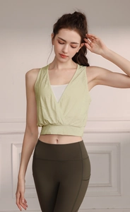 Detail of green criss-cross V-neck yoga vest and high-waisted fitness leggings for women