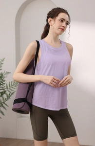 Dettaglio del top da yoga lilla con schiena scoperta e leggings verdi con tappetino