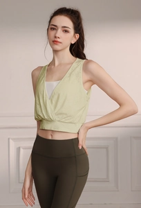 Detail of lime green yoga tank top with V-neck cross design and olive green leggings