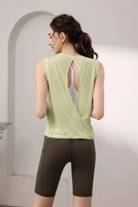 Detail view of lime green open back yoga top and olive green cycling shorts