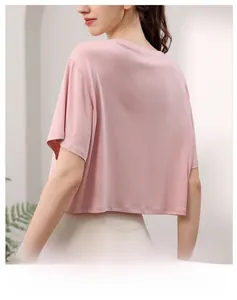 Vue de dos d'une femme portant un t-shirt de yoga rose en modal et tissu respirant