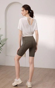Détail du t-shirt blanc à dos croisé et du short de yoga vert olive à poches latérales