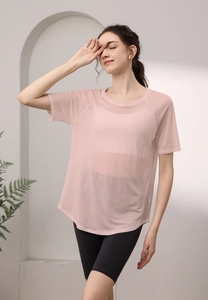 Vue détaillée du haut de yoga rose en maille respirante avec une coupe à ourlet arrondi