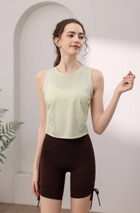 Detail view of light green tencel tank top and brown yoga shorts with side drawstring