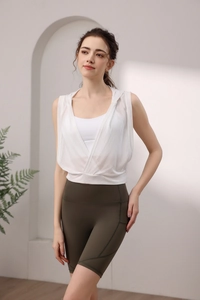 Haut de yoga à capuche blanc sans manches avec short cycliste vert sur un mannequin