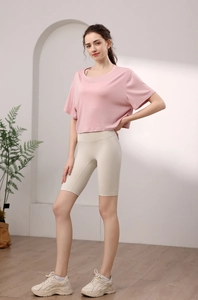 Haut de yoga en modal rose et short taille haute beige sur modèle en studio minimaliste