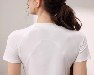 Dettaglio maglietta da yoga bianca con maniche raglan e cuciture curve sulla schiena