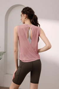 Detail of tencel open back yoga top with criss-cross straps and green biker shorts