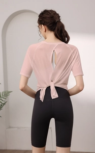 Vue détaillée du dos du haut de yoga rose avec fente élégante et short de cyclisme noir