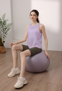 Dettaglio del top da yoga in tencel viola e pantaloncini da ciclista verdi