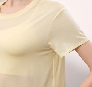 Detail des hellgelben atmungsaktiven Netzgewebes am locker sitzenden Yoga-T-Shirt