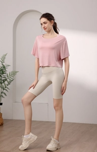 Détail du crop top de yoga en modal rose et short cycliste blanc cassé sur un modèle