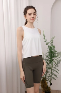 Dettaglio della canotta sportiva in nylon bianco e pantaloncini da yoga a vita alta verdi
