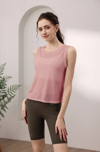Close-up of a pink open back yoga top and high-waist green cycling shorts on model
