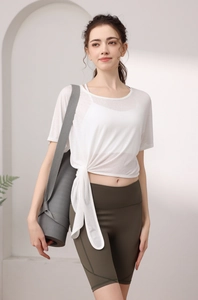 Détail du haut de yoga blanc respirant avec lien latéral et short de sport vert olive