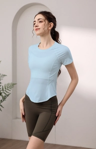 Dettaglio della maglietta fitness azzurra con orlo curvo e pantaloncini da ciclista oliva