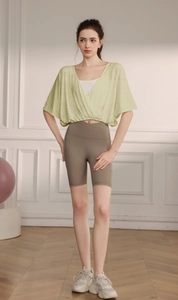 Detail of breathable jacquard mesh texture on pale green batwing yoga top with side pockets
