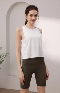 Dettaglio di canotta sportiva in nylon bianco e pantaloncini fitness a vita alta oliva