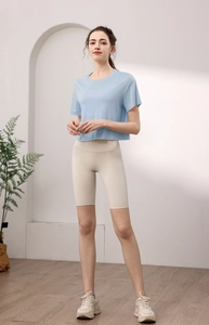 Detail eines hellblauen Yoga-T-Shirts kombiniert mit beigen Radlerhosen beim Training