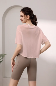 Detail der lockeren hellrosa Yoga-Bluse und Khaki-Radlerhose mit hoher Taille für Damen