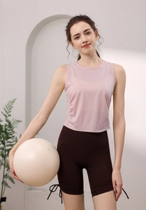 Detail of light pink sleeveless yoga top featuring breathable tencel fabric and side tie knot