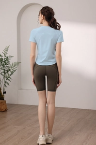 Dettaglio della maglietta da yoga blu traspirante e dei pantaloncini fitness verde oliva
