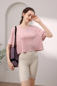 Détail du haut de yoga rose en modal et du short cycliste beige à taille haute sur un modèle