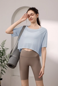 Detail von hellblauem Yoga-Top mit hoch taillierten mokkafarbenen Radlerhosen