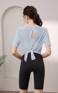 Détail du haut de yoga bleu clair avec fente arrière élégante et nœud sur le mannequin