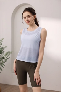 Close-up of light blue mesh yoga top layered over white sports bra with olive shorts
