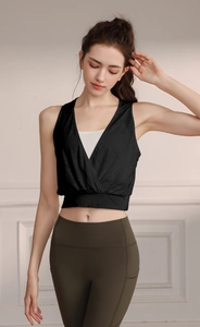 Detail of a black V-neck sports vest with white inner layer and olive green yoga leggings