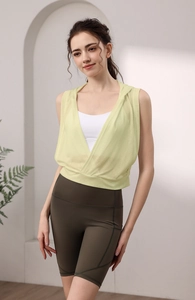 Vue détaillée du tissu respirant et de l'ourlet croisé d'un gilet de yoga jaune citron
