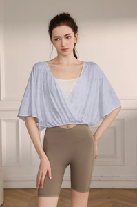 Detail of light purple batwing sleeve yoga top with V-neck wrap design and jacquard fabric