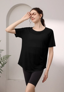 Détail du haut de yoga noir respirant avec ourlet fendu et manches raglan pour sport