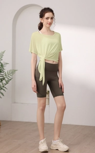 Détail du haut de yoga noué vert clair et du short de cyclisme taille haute olive