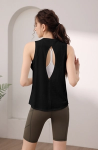 Dettaglio posteriore di un top da yoga nero senza schienale con reggiseno sportivo bianco