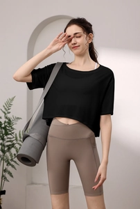 Detail eines schwarzen Crop-Yoga-Tops und brauner Fitness-Leggings mit hohen Taillen