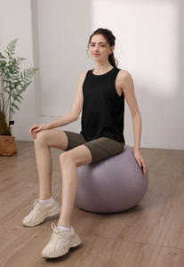 Dettaglio del set fitness da donna con canotta nera e pantaloncini da ciclista oliva