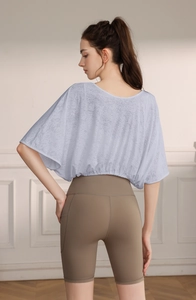Detail of light blue batwing sleeve jacquard top showing breathable texture and fit