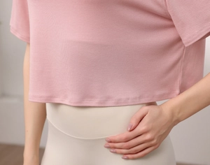 Gros plan d'un crop top de yoga en modal rose avec texture côtelée et col rond
