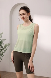 Detail of light green breathable mesh yoga tank top layered with dark olive gym shorts